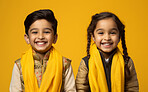 Studio portrait of two cute hindu kids. Against yellow backdrop. religion concept.