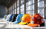 Multicolour construction hard hats on floor in a row. Safety at work concept