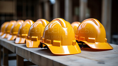 Multiple yellow hard hats stacked on factory table. Labour day concept.