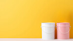 Paint buckets against yellow wall. Copy space. DIY renovation concept.