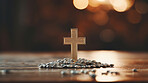 Close up of small cross with little stones on table. Religion and faith concept.