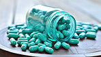 Green pills in glass container. Health supplement and science medicine research concept