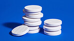 White fizz tablets on blue background. Health supplement and science medicine research concept