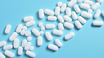 White pills on blue background. Health supplement and science medicine research concept