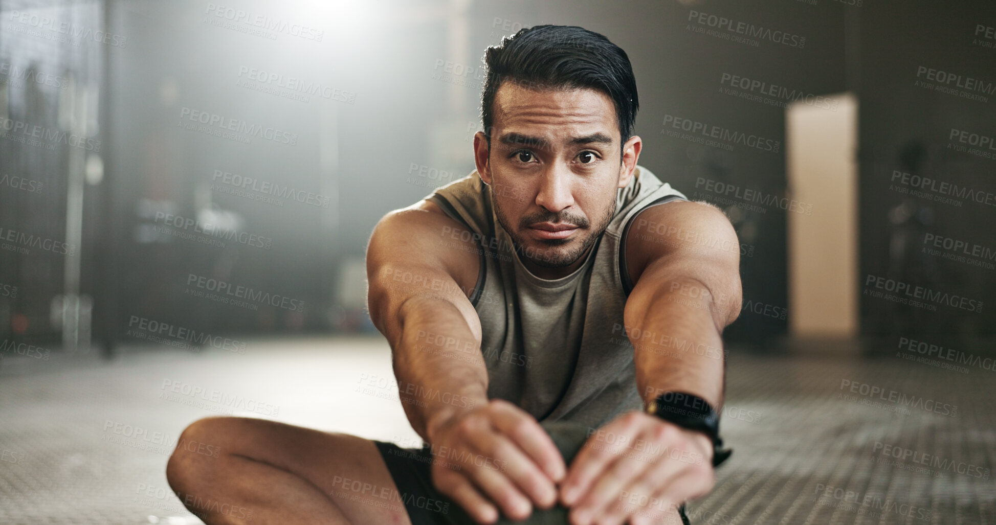 Buy stock photo Man stretching on floor of gym for strong body, muscle development or balance in power fitness. Commitment, motivation and focus on ground, bodybuilder in energy training workout and exercise mindset