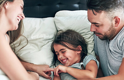 Buy stock photo Cropped shot of a family having fun while lying in bed at home