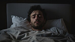 Depressed sleeping man in bed at home. Concept for mental health awareness