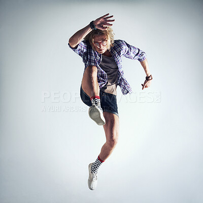 Buy stock photo Shot of a handsome young man dancing against a gray background