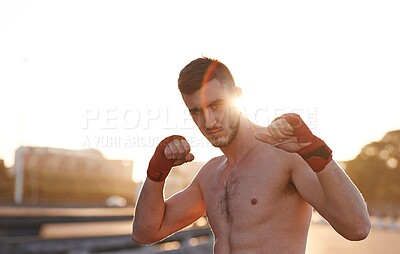 Buy stock photo A serious young mma fighter with his fists up