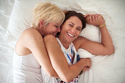 Buy stock photo High angle shot of a loving lesbian couple lying in bed