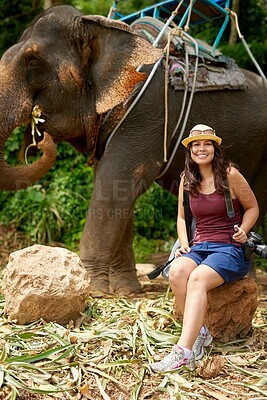 Buy stock photo Portrait of a young tourist sitting in a tropical rainforest with an elephant in the background