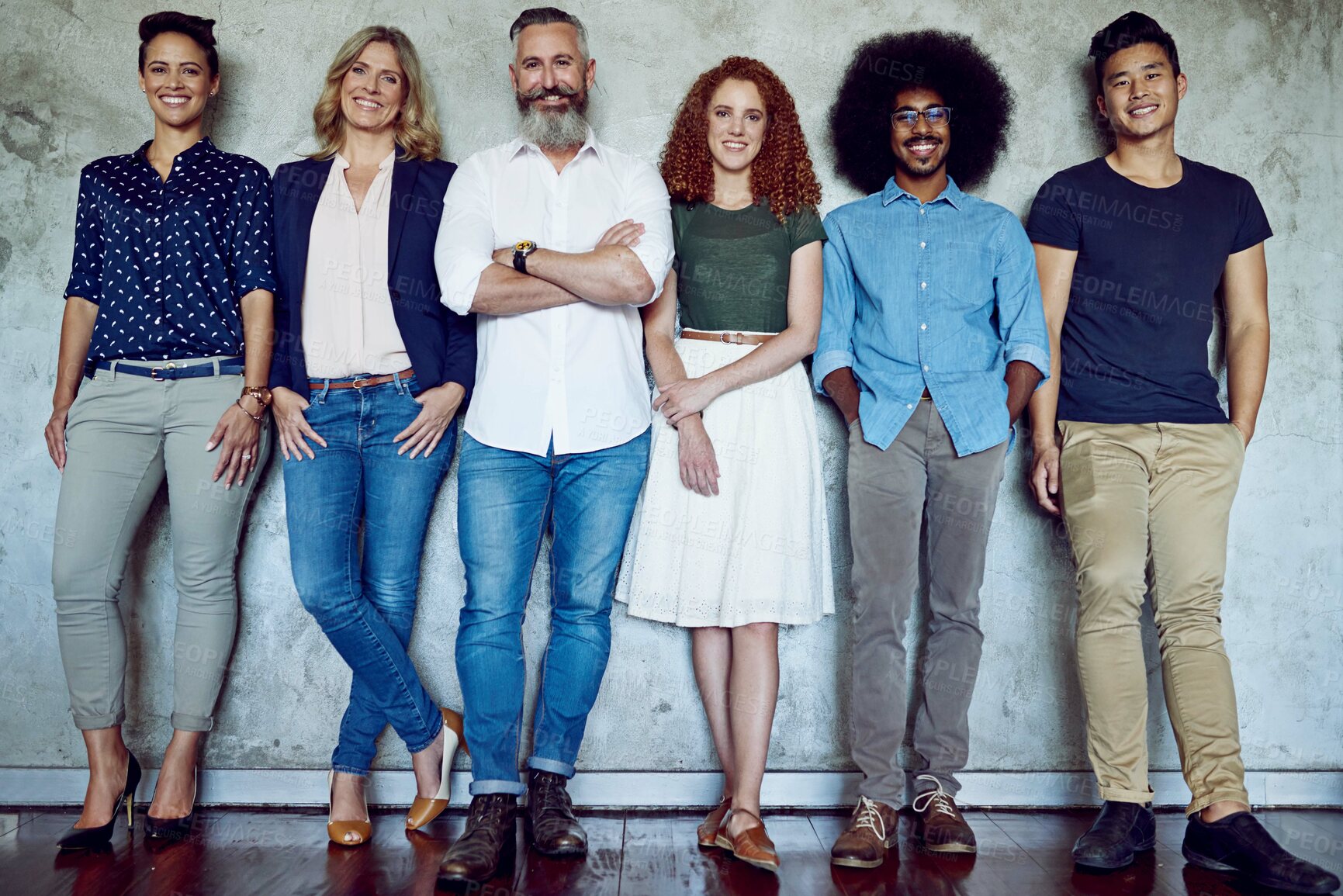 Buy stock photo Portrait of a group of designers standing against a wall in an office