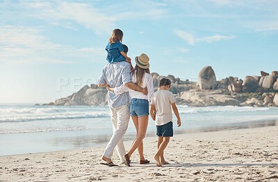 Buy stock photo Rearview shot of an affectionate couple holding hands with their two young children and walking along the beach