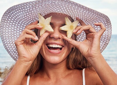 Buy stock photo Woman, portrait and fruits with hands for nutrition on holiday by the ocean with sunshine. Female person, cheerful and fruit on face for diet in the sun on the beach for fun on holiday in summer.