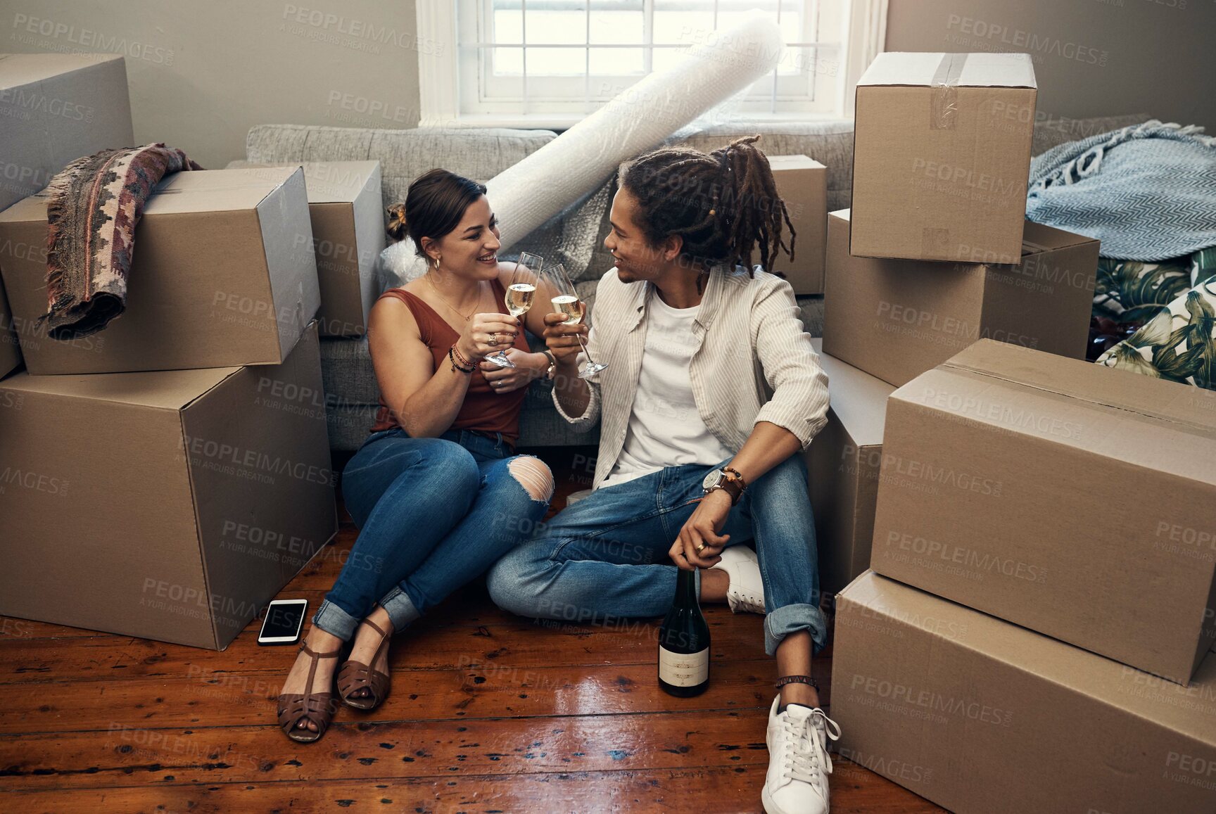 Buy stock photo Shot of a happy young couple having champagne to celebrate their new home