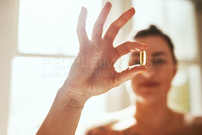 Buy stock photo Shot of a woman taking a pill during her morning routine at home