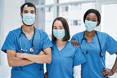 Buy stock photo Portrait of a group of medical practitioners wearing face masks in a hospital