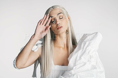 Buy stock photo Cropped shot of an attractive young woman posing with her eyes closed against a grey background in studio