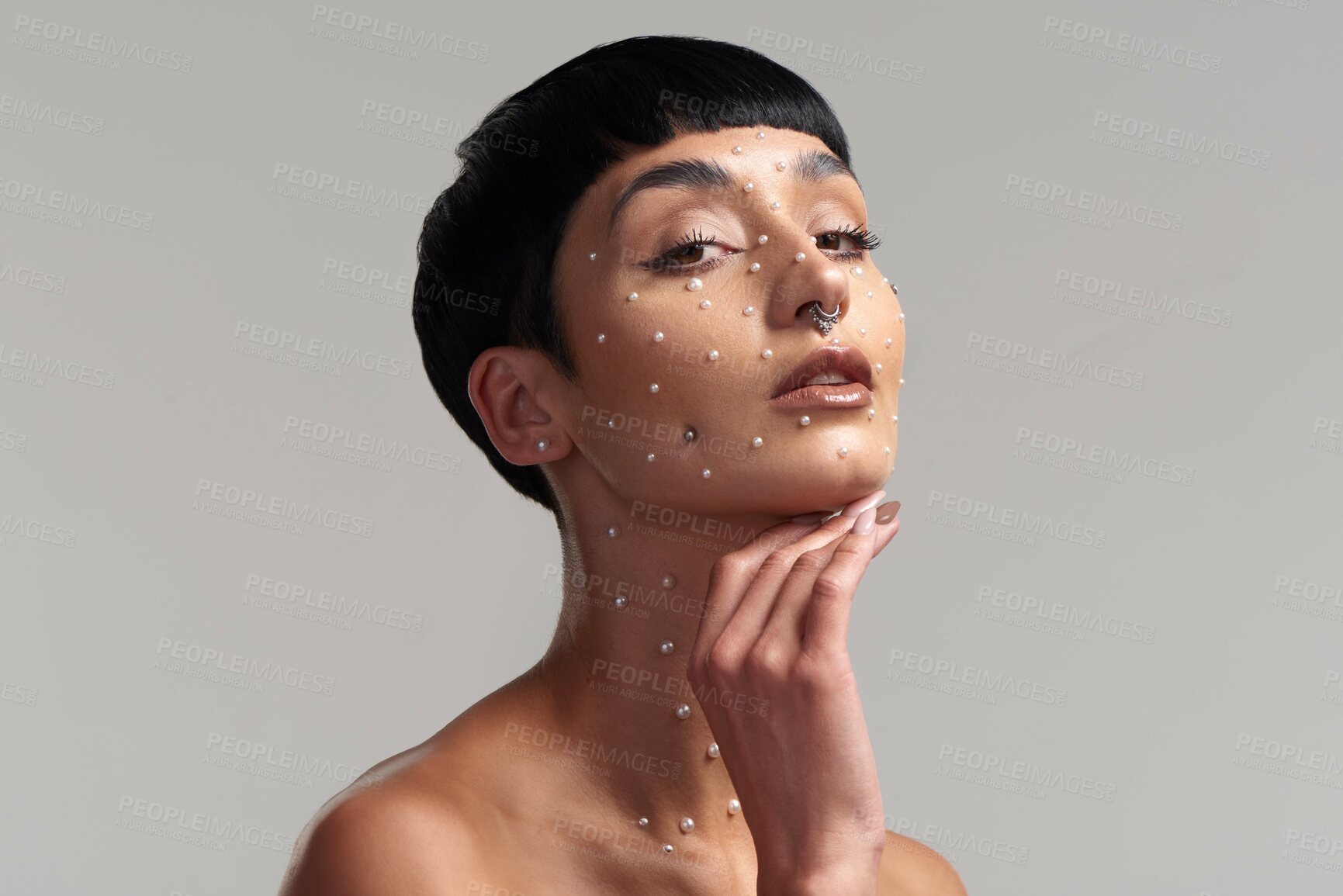 Buy stock photo Studio portrait of a beautiful young woman with pearls on her face posing against a grey background