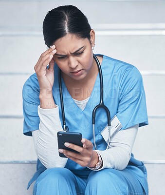 Buy stock photo Shot of a female nurse looking upset while using her cellphone