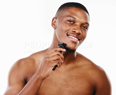 Buy stock photo Studio portrait of a handsome young man shaving his facial hair with an electrical razor against a white background