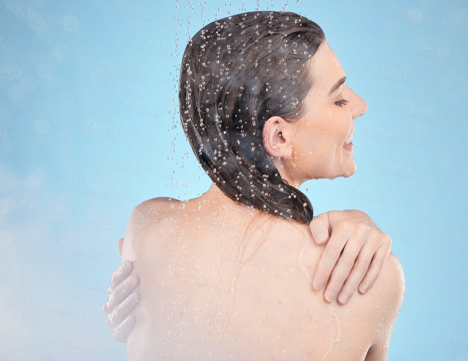 Buy stock photo Shower, happy and beauty of wellness woman with body cleaning, self care and grooming routine. Health, hydration and water drops on back of skincare model washing in blue studio with smile.