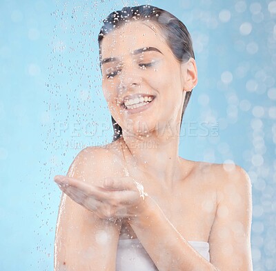 Buy stock photo Beauty splash, skincare and woman in a shower for luxury, wellness and cleaning in studio with mockup. Water splash, model and girl relax in water, face and hair, care and moisture on blue background