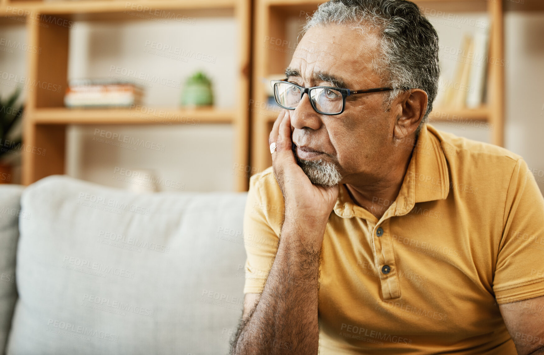 Buy stock photo Face, depression and thinking with a sad old man on a sofa in the living room of his retirement home. Mental health, alzheimer or dementia and a senior person looking lonely with memory nostalgia