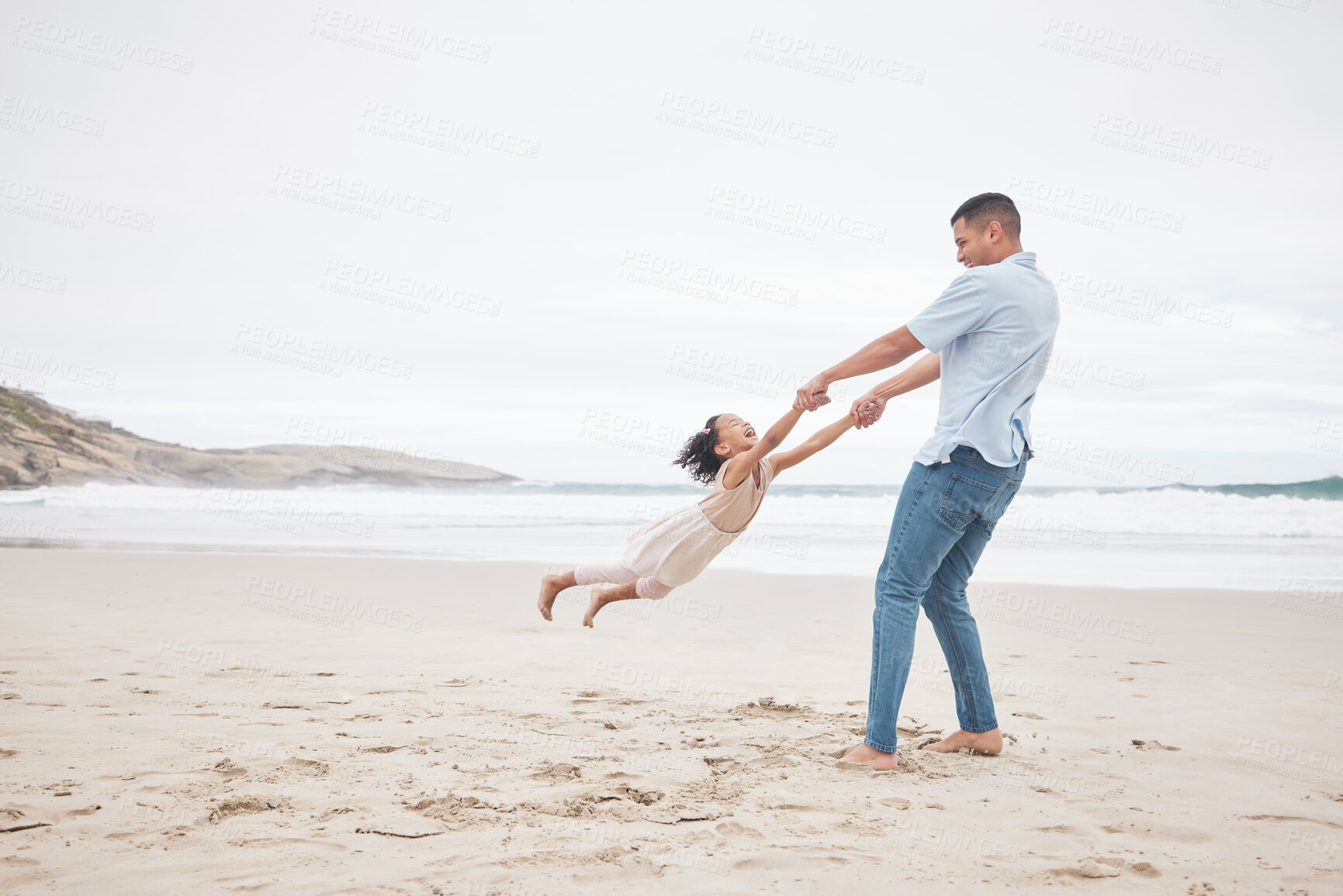 Buy stock photo Swinging, happy and a father and child at the beach for fun, bonding and love in summer for vacation. Playful, laughing and a young dad spinning a girl kid at the ocean for freedom and love together