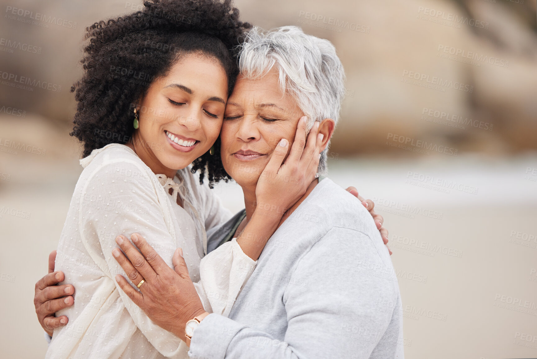 Buy stock photo Women, mother and daughter on beach, hugging and smiling in embrace, love and happiness. Family vacation, joy and bonding for retirement, resting and relaxation on ocean, enjoying and quality time