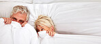 Senior couple, hiding and smile in bed for fun, comfort and bonding for love, silly and goofy together. Elderly people, marriage and sex in bedroom in retirement, romance and happiness at home