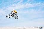 Motorbike, jump and man in the air with blue sky, mock up and stunt in sports with fearless person in danger with freedom. Motorcycle, jumping and athlete training for challenge or competition