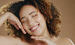 Happy model, natural beauty or smile for wellness in studio with confidence, eyes closed or skin glow. Face, proud woman or healthy biracial female person with skincare results on brown background