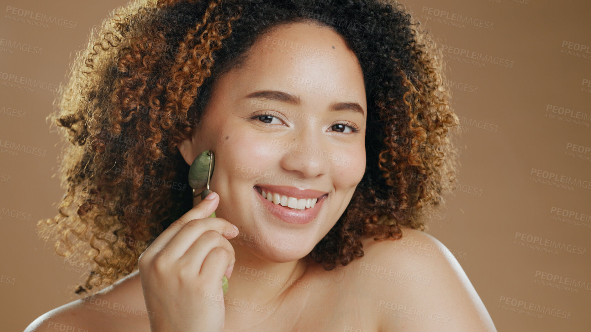 Buy stock photo Portrait of happy woman, smile or jade roller in studio with anti aging product or facial tool to relax. Brown background, results or healthy model with cosmetics for wellness or natural skincare