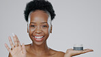 Black woman, portrait and cream with smile, skincare and healthy skin with face, moisturizer and blue studio background. Happy, afro and sunscreen for dermatology, cosmetology and luxury product