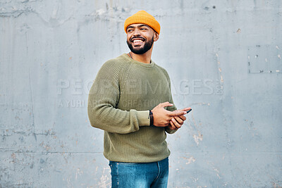 Buy stock photo Phone, happy and young man by wall networking on social media, mobile app or the internet. Technology, smile and male person from Colombia scroll on website with cellphone in city by gray background.