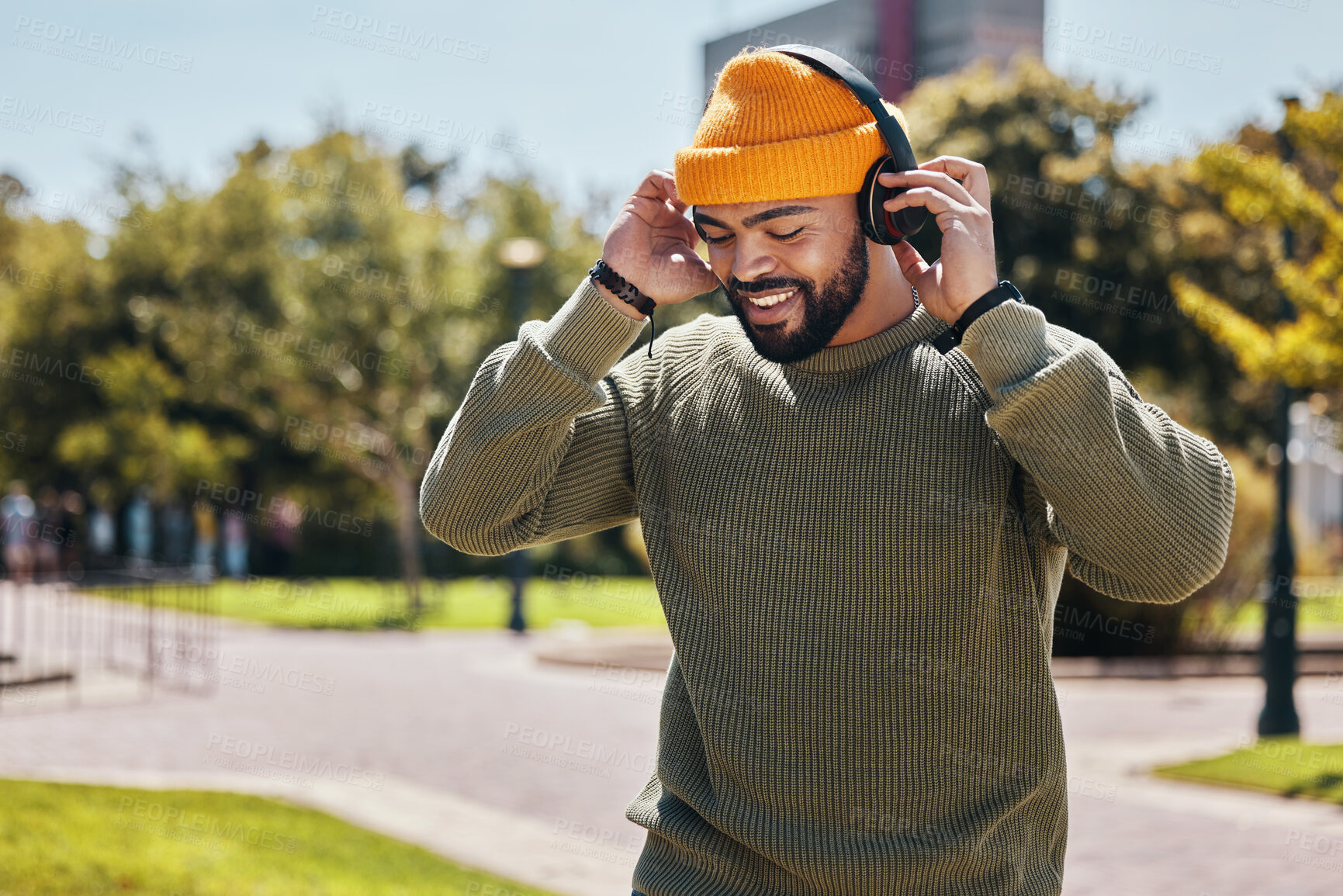 Buy stock photo Music, headphones and happy man at park outdoor, listening to audio online and hearing sound track on podcast technology. Smile, streaming radio and person at garden for freedom in nature in summer