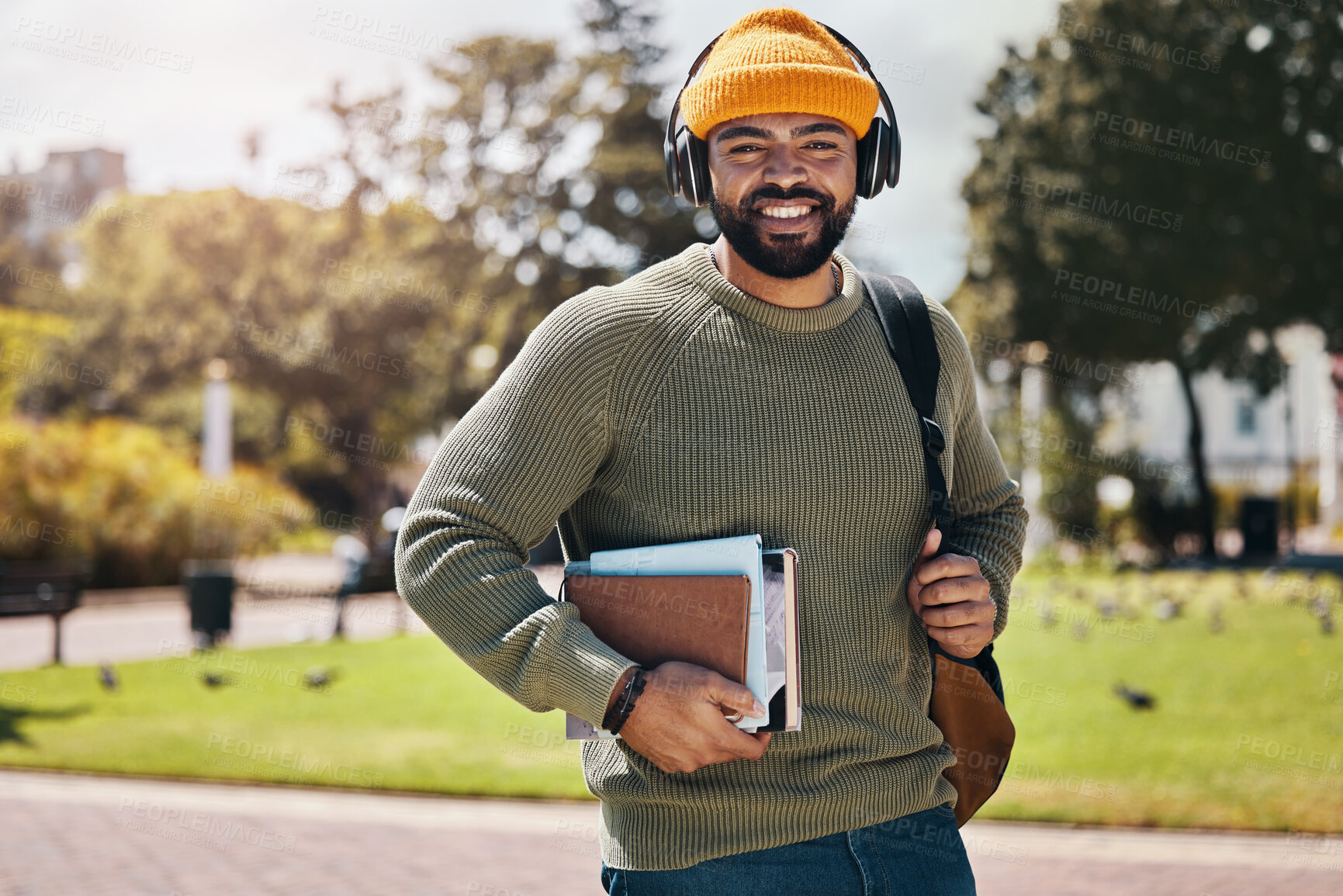 Buy stock photo Student, headphones and backpack on campus of education, college or university podcast in park. Portrait of african man walking, travel and books with audio, electronics or listening to music outdoor