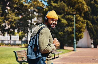 Buy stock photo Portrait, outdoor and man with headphones, streaming music and connection with radio, sunshine and listening to audio. Face, person or student with a backpack, headset and podcast with sound or gen z