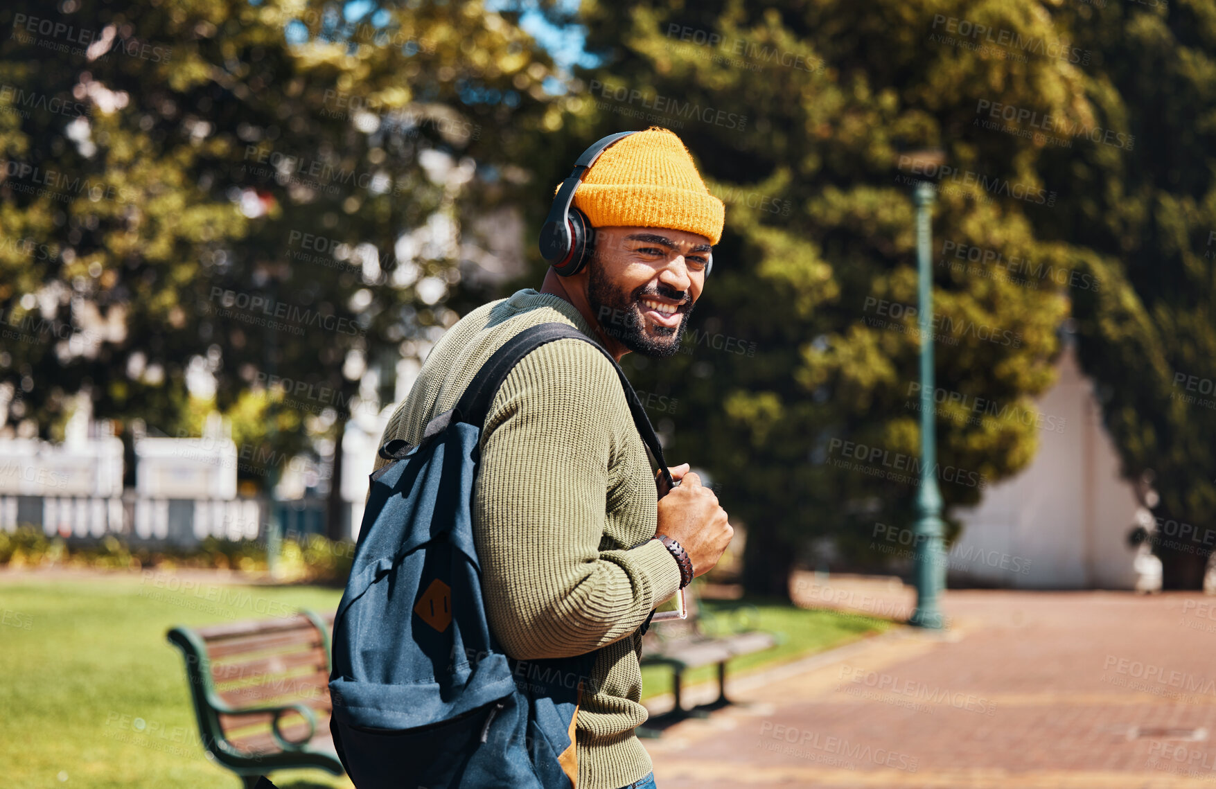 Buy stock photo Portrait, outdoor and man with headphones, streaming music and connection with radio, sunshine and listening to audio. Face, person or student with a backpack, headset and podcast with sound or gen z