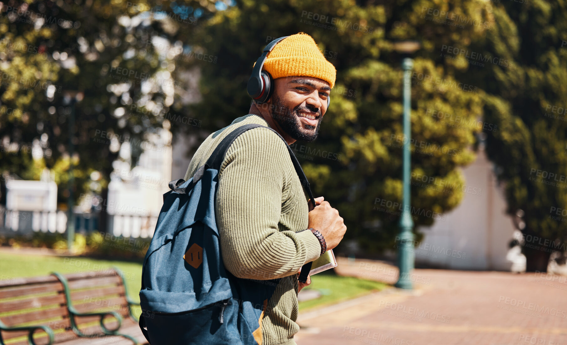 Buy stock photo Portrait, outdoor and man with headphones, smile and streaming music with connection, sunshine and listening to audio. Face, person or student with a backpack, headset and podcast with sound or radio