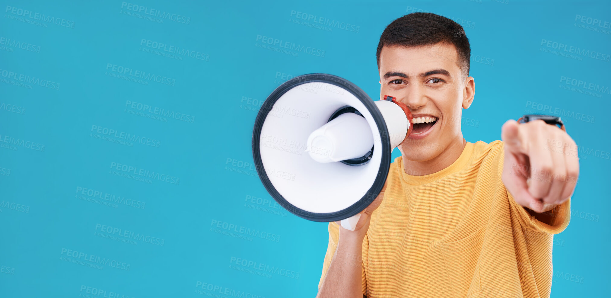 Buy stock photo Megaphone, smile and portrait of man in studio pointing for announcement, speech or rally. Happy, protest and young person from Canada with bullhorn for loud communication isolated by blue background