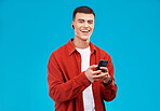 Man, phone and listening to music in studio with social media, college contact and communication on a blue background. Portrait of person or student in USA with mobile, earphones or audio streaming 