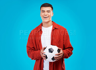 Buy stock photo Soccer ball, happy and portrait of man on blue background for sports, winner and achievement. Smile, football fan and person cheer for team success, winning match, game and tournament in studio