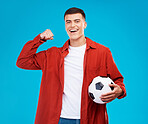 Portrait, football and happy man with strong muscle in studio isolated on a blue background. Face, soccer and excited person flex bicep for power, sports and success in competition, winner and goal