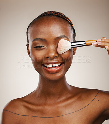Buy stock photo Black woman, portrait and brush for makeup on eye with beauty and smile for dermatology on studio background. Glow, foundation or powder with cosmetic tools, wellness and cosmetology with skincare