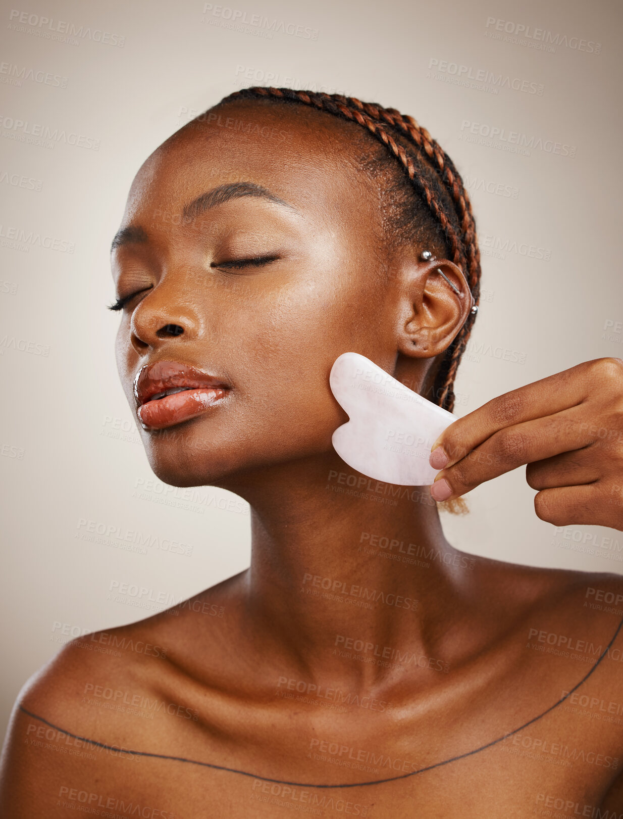 Buy stock photo Woman, beauty and gua sha for face massage, aesthetic skincare and anti aging dermatology in studio on grey background. African model, crystal stone tools or lymphatic drainage with facial cosmetics