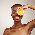 Black woman, orange fruits and beauty in studio for vitamin c, vegan cosmetics and facial on brown background. Happy model, citrus and nutrition for natural skincare, organic benefits and detox diet 