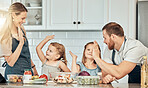 Family in kitchen, cooking together with high five and teaching kids, learning nutrition and happy parents. Mom, dad and girl children help making healthy food in home with care, success and lunch.