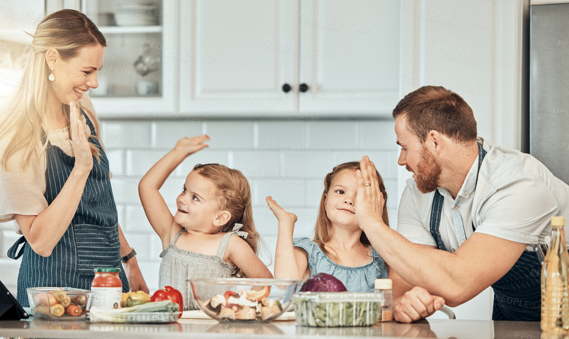 Buy stock photo Family in kitchen, cooking together with high five and teaching kids, learning nutrition and happy parents. Mom, dad and girl children help making healthy food in home with care, success and lunch.